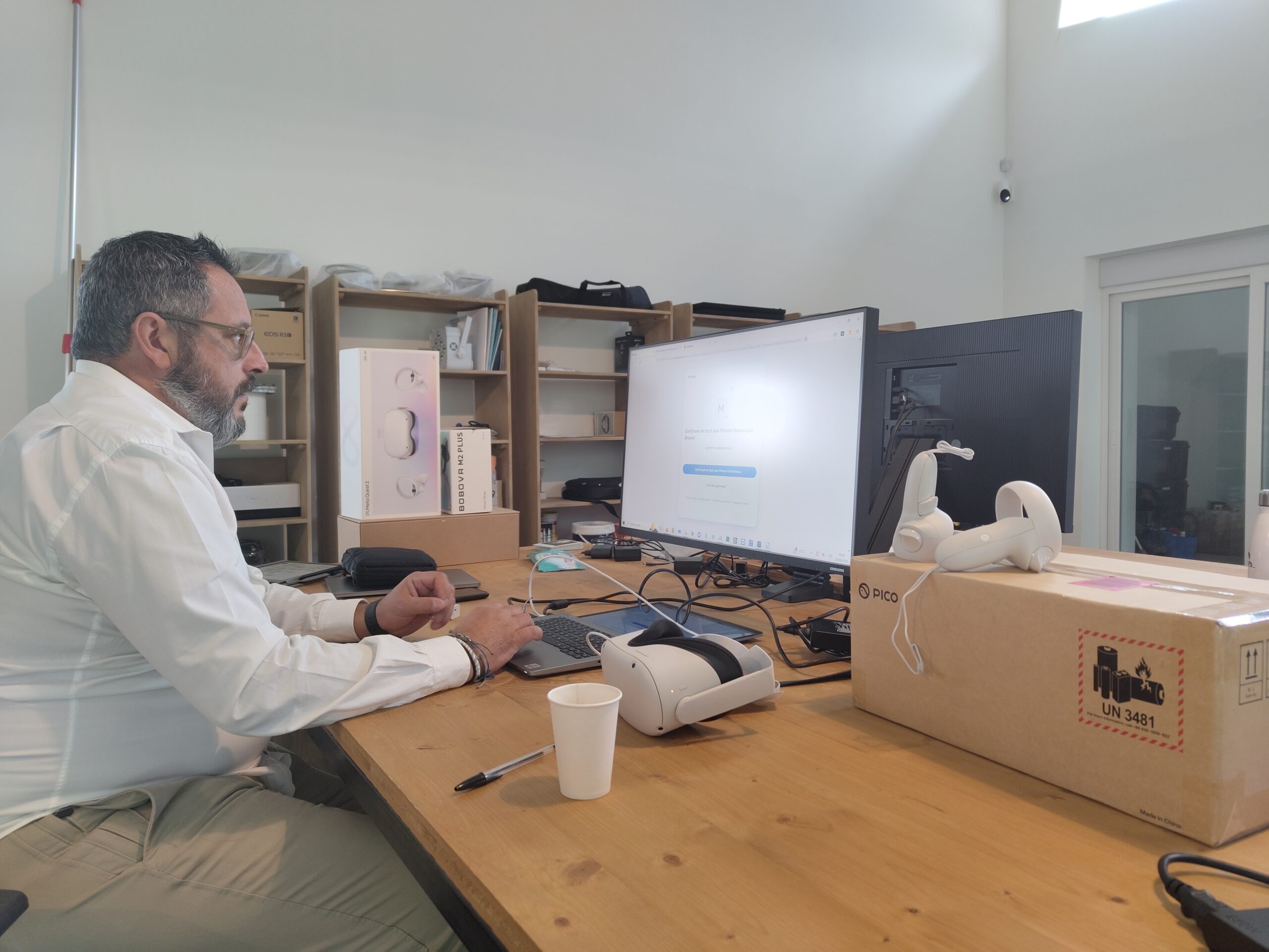 Poste de travail avec développement d'une application de réalité virtuelle et casque posé sur le bureau